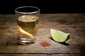 Tequila shot with lime and salt on vintage background.